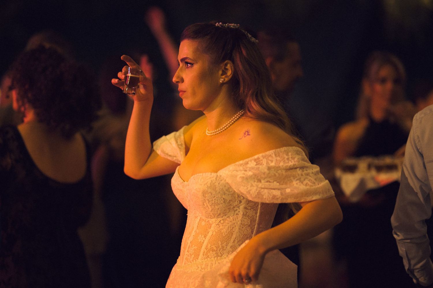 Dancers in formal attire perform at an elegant ballroom event with dim lighting and romantic atmosphere.