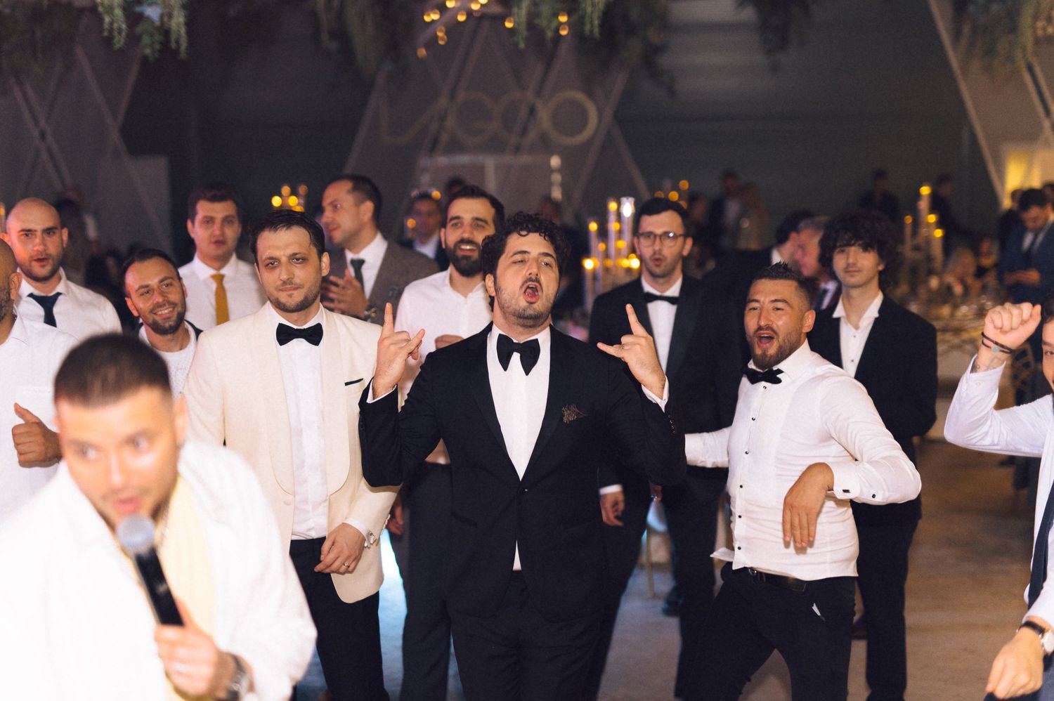 A group of people in formal black and white attire stand together at an elegant event.