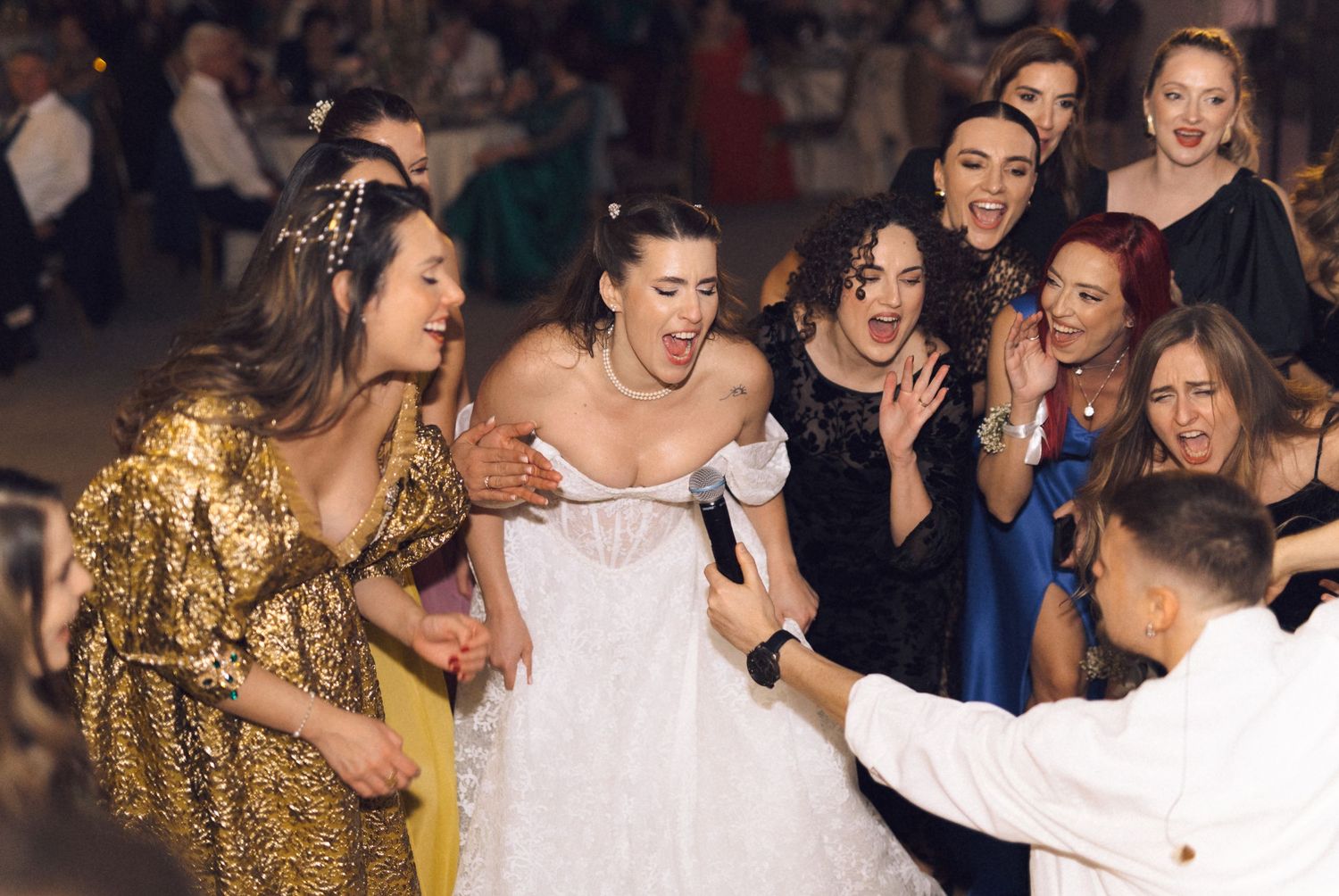 Guests dance and celebrate joyfully at a wedding reception with a glowing party atmosphere.