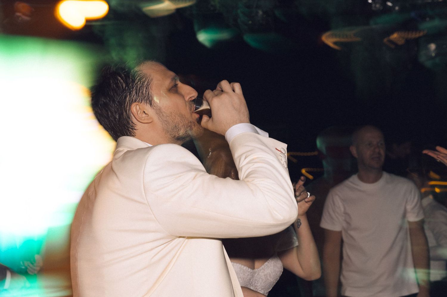 People dancing together in a dimly lit nightclub or dance venue with atmospheric lighting.
