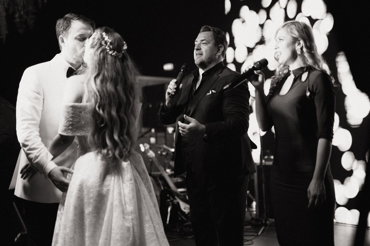 A group of elegantly dressed people performing together at a formal black and white event.