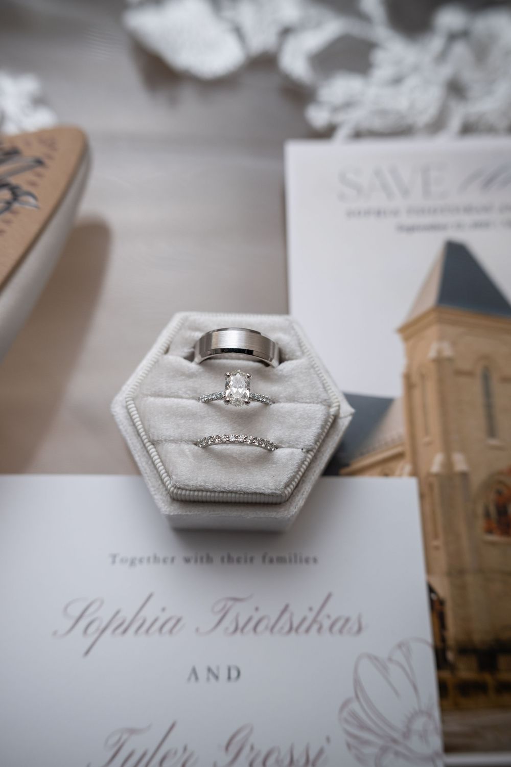 Wedding invitation details and diamond engagement ring photographed in soft focus with elegant typography and decor.