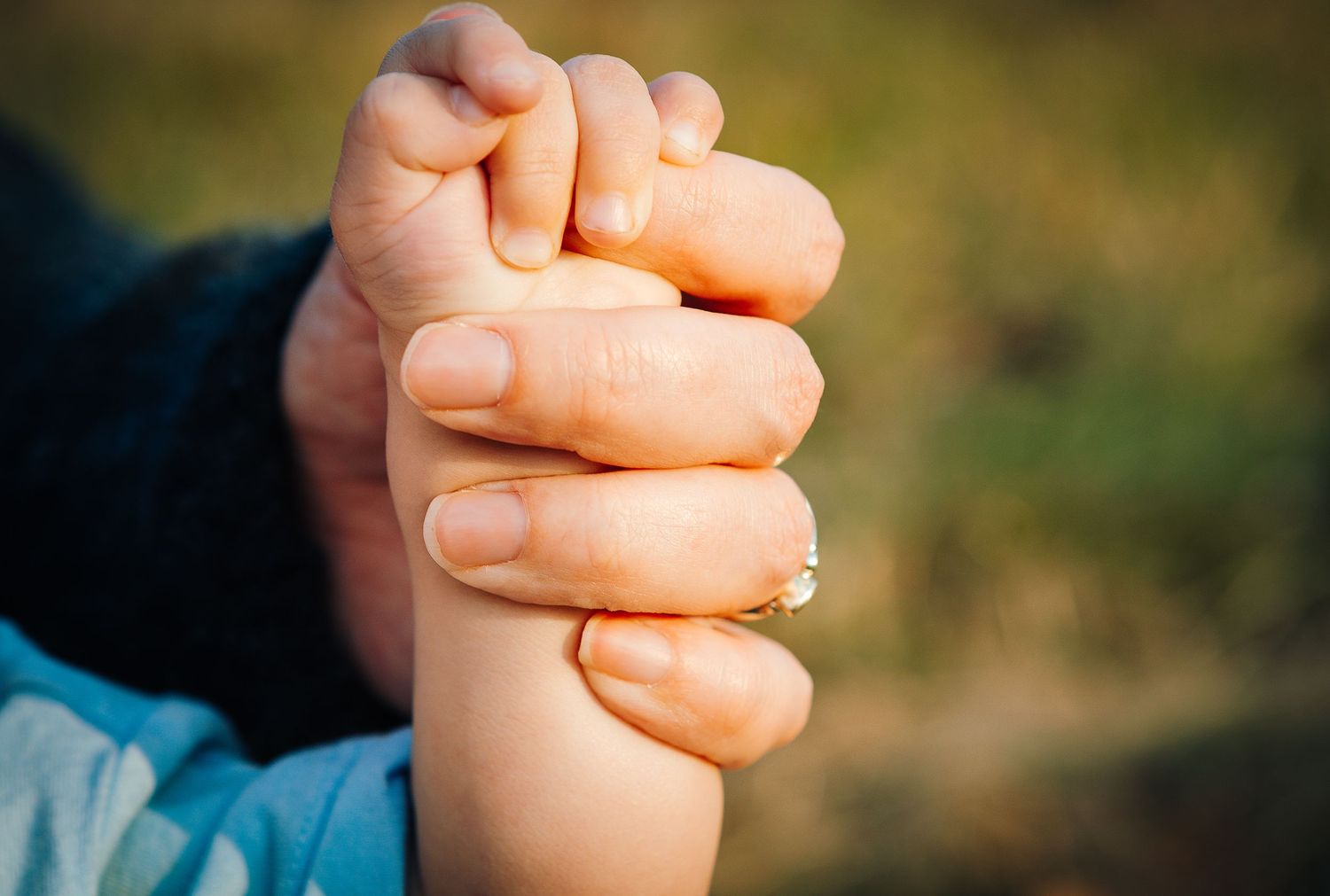 mom holding baby hand during golden hour family photoshoot in Lake Junaluska, NC