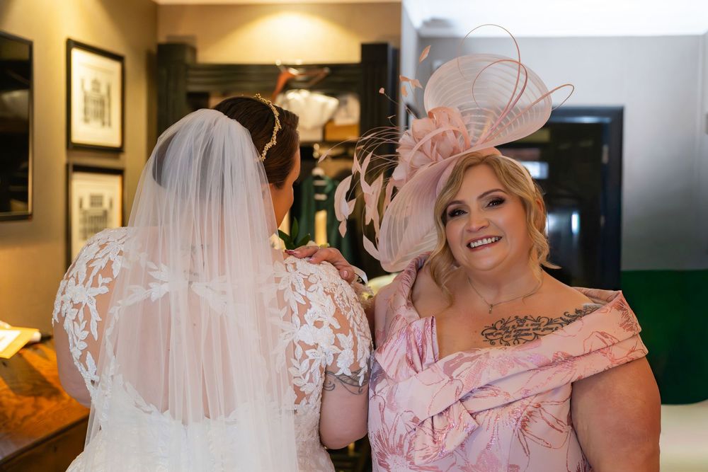 A wedding party in pink dresses and formal attire poses together during a celebration.