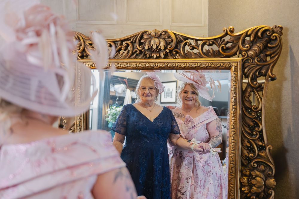 Ornate gold frames display wedding photos and decor in an elegant room setting.