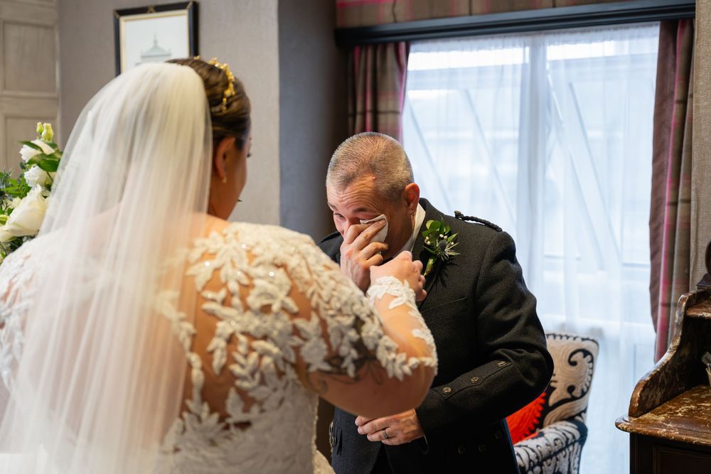Emotional first look moment between a bride and family member during a wedding ceremony.