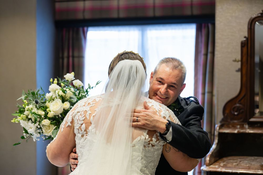 Emotional wedding preparations showing tender moments between family members in a sunlit room.