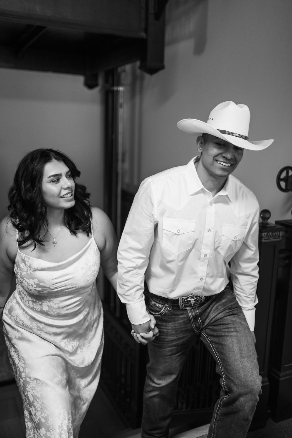 A black and white photo series showing a couple dancing together in western attire and wedding dress.