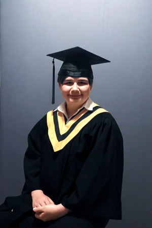 Graduate in black cap and gown with yellow trim poses in a sequence of four photos against a gray background.