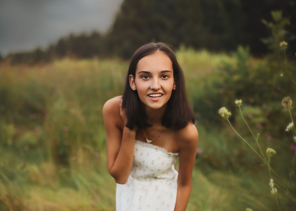 Outdoor portrait session in a natural field setting during golden hour.