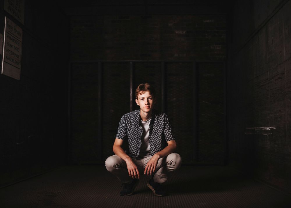 Dark and moody indoor portrait series with dramatic lighting and shadows.