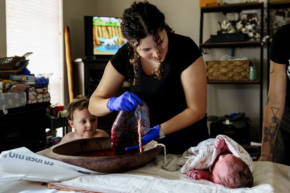 A person wearing gloves prepares raw meat on a cutting board in a home kitchen setting.