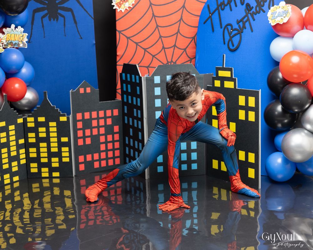 Spider and web decorations against a city skyline backdrop create a spooky Halloween party atmosphere.