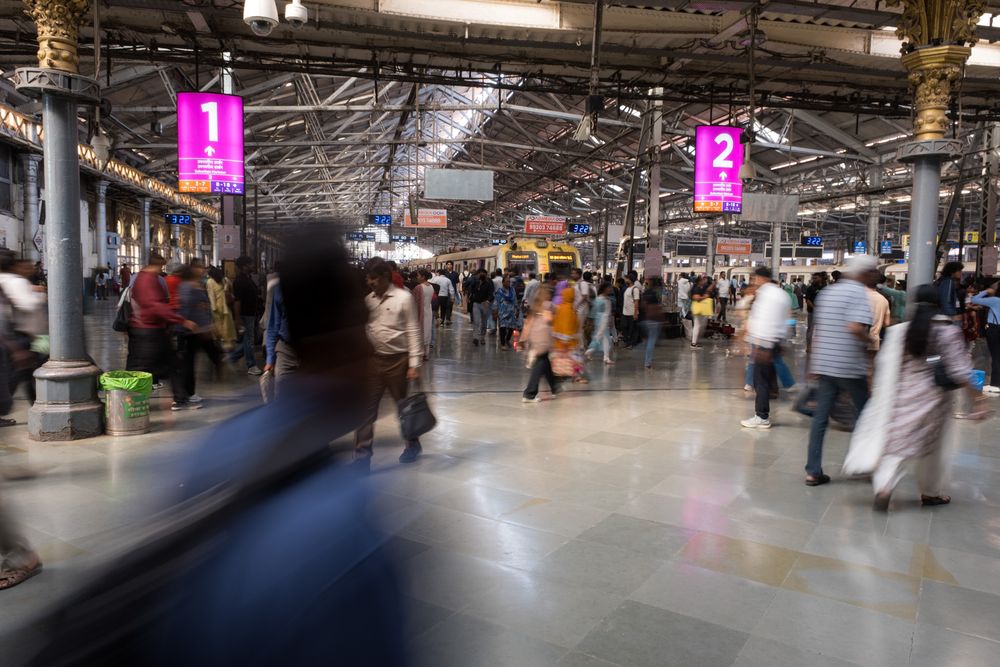 Busy commuters in motion blur inside Chhatrapati Shivaji Terminus railway station Mumbai.