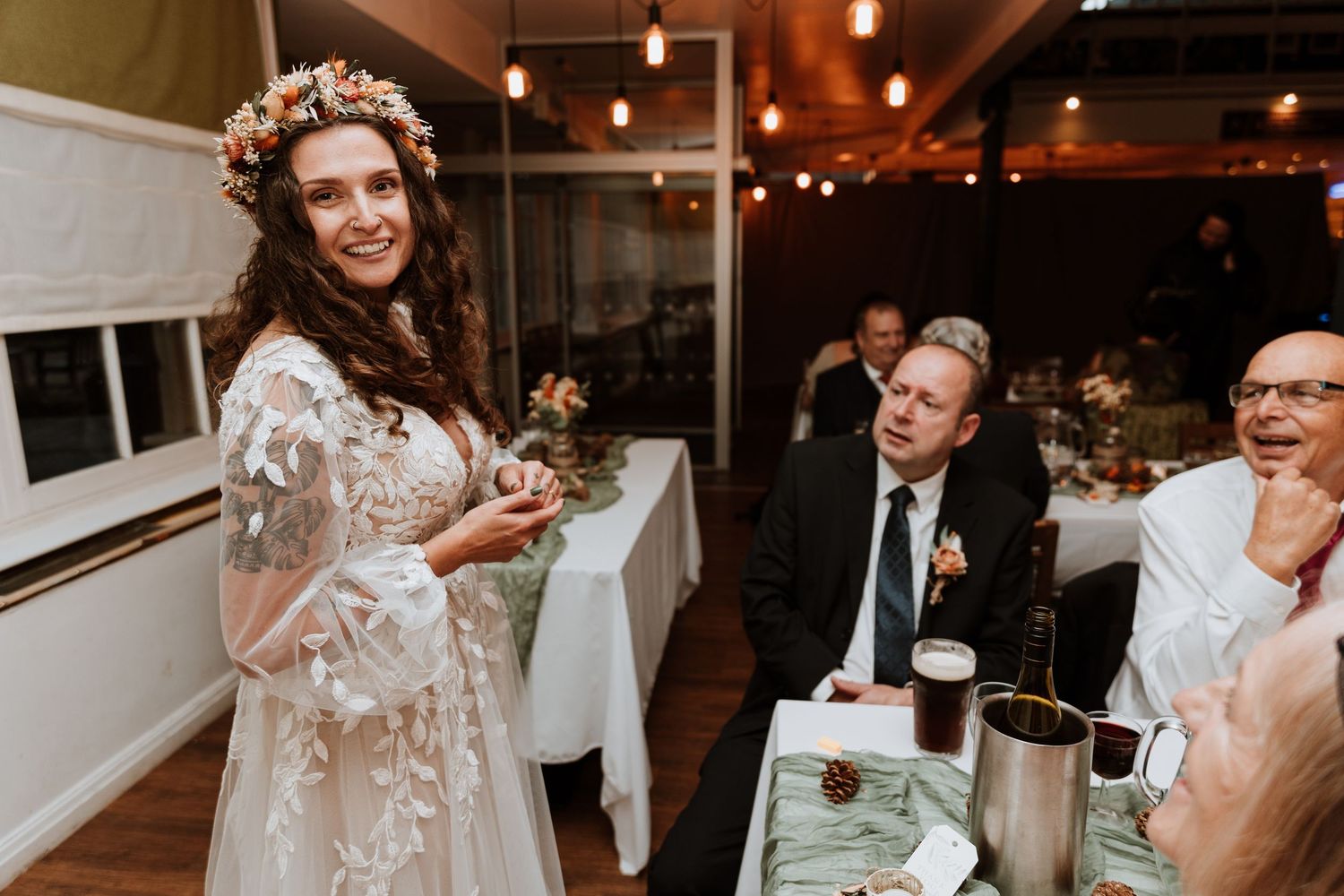 A candid wedding reception moment showing laughter and joy during an indoor evening celebration.