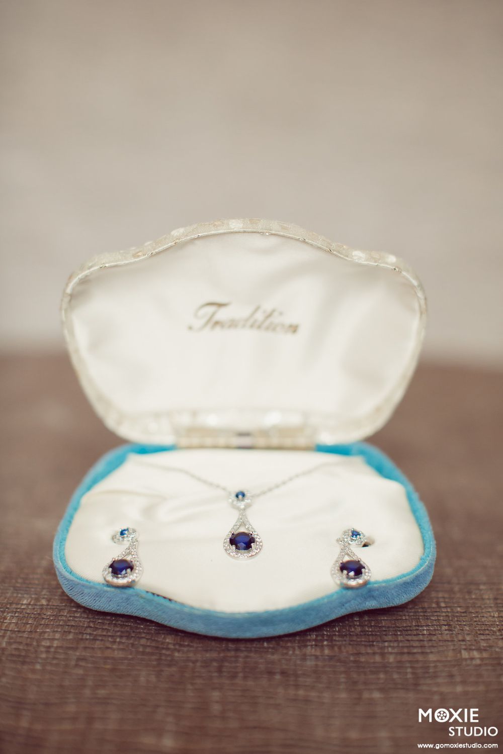 Sequence of wedding ring pillow photos showing decorative blue trim and purple gemstone embellishments on white fabric.