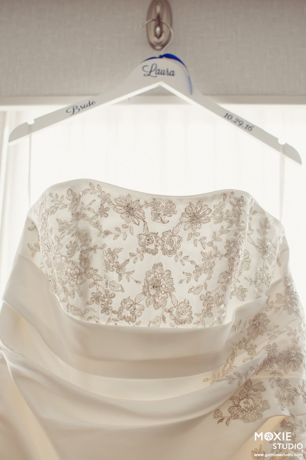 Close-up view of intricate lace and beadwork details on the bodice of an ivory wedding gown.