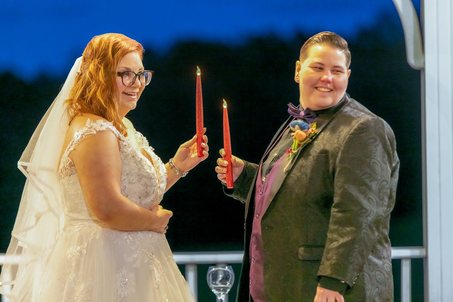 A couple exchanges vows during a wedding ceremony with an officiant in formal attire.