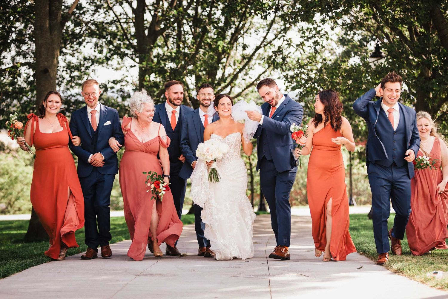 Bride and groom walking with their bridal party during wedding photos at Dorchester Heights in South Boston