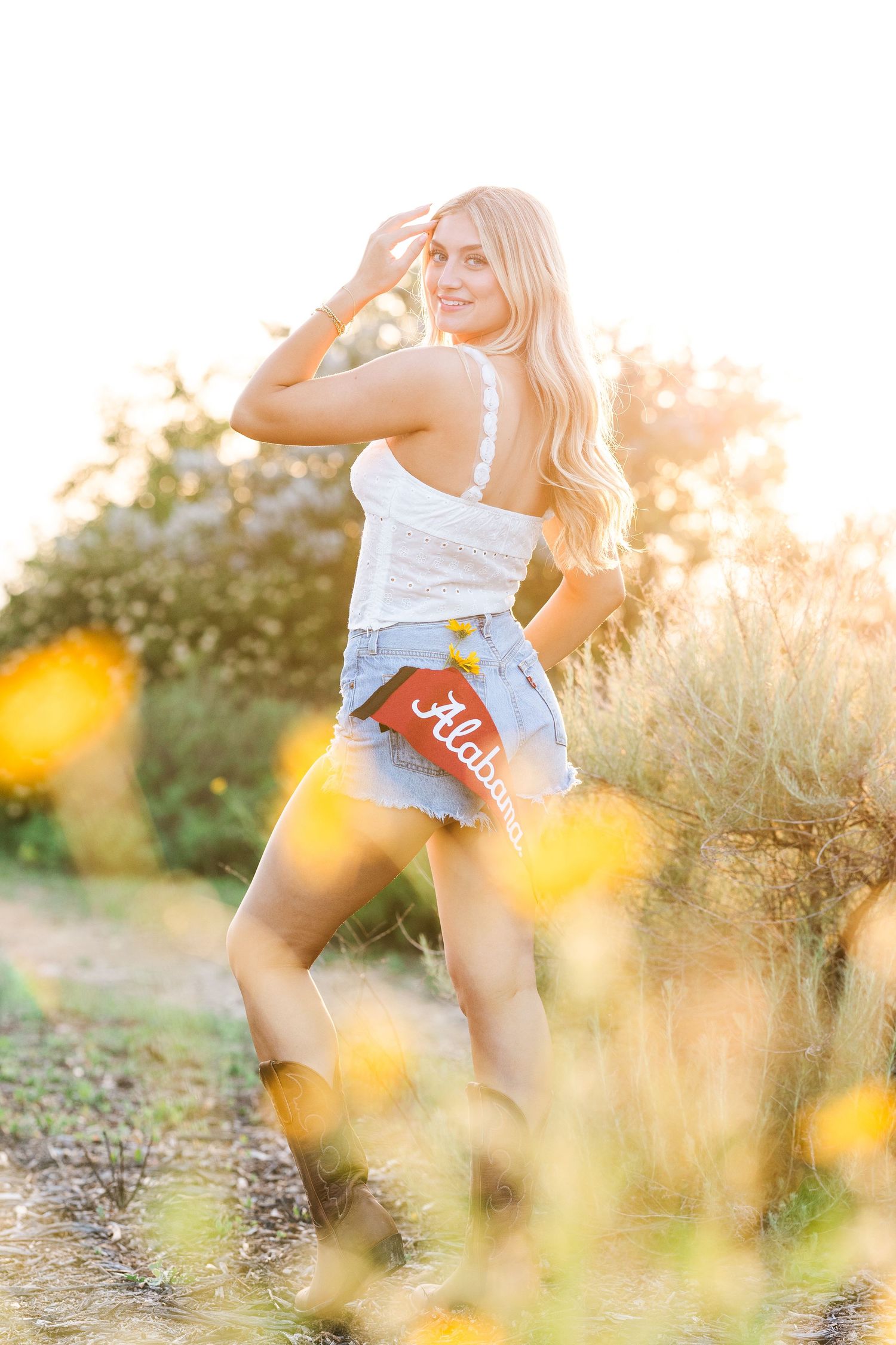 Artistic outdoor portrait series at sunset with yellow wildflowers in foreground and dreamy golden light.