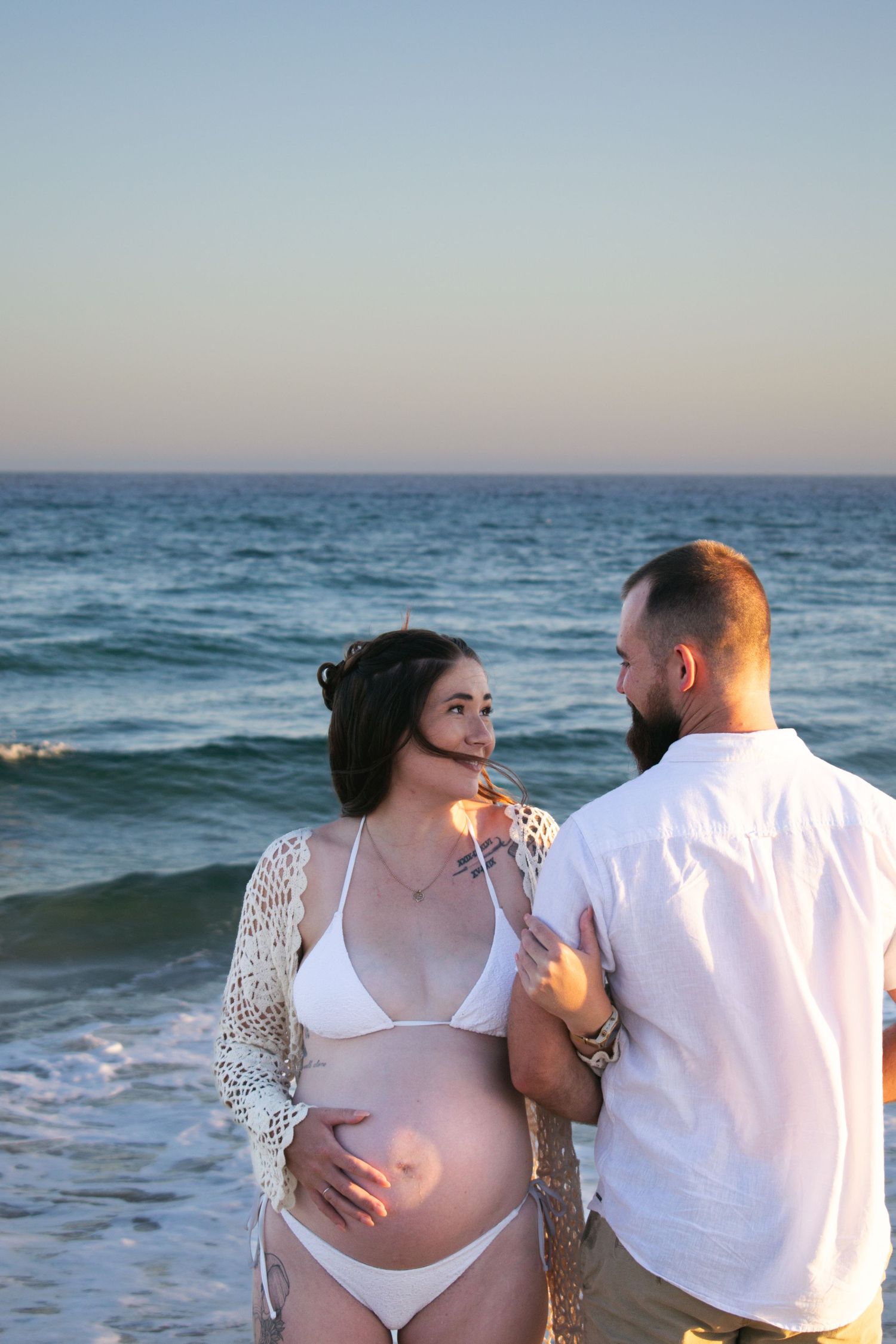 Newcastle maternity photographer capturing mother-to-be at the beach at golden hour