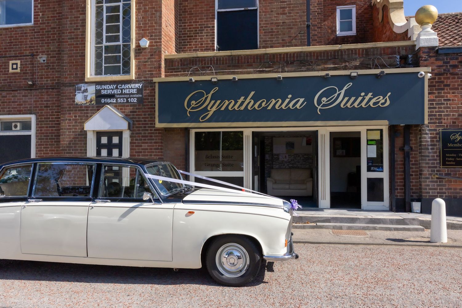 Historic brick building facade with Synthonia Suites signage and classic car parked in front. Synthonia Suites Billingham Stockton