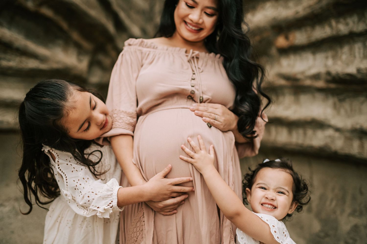 A tender maternity photoshoot in a rustic setting with soft natural lighting and intimate family moments.