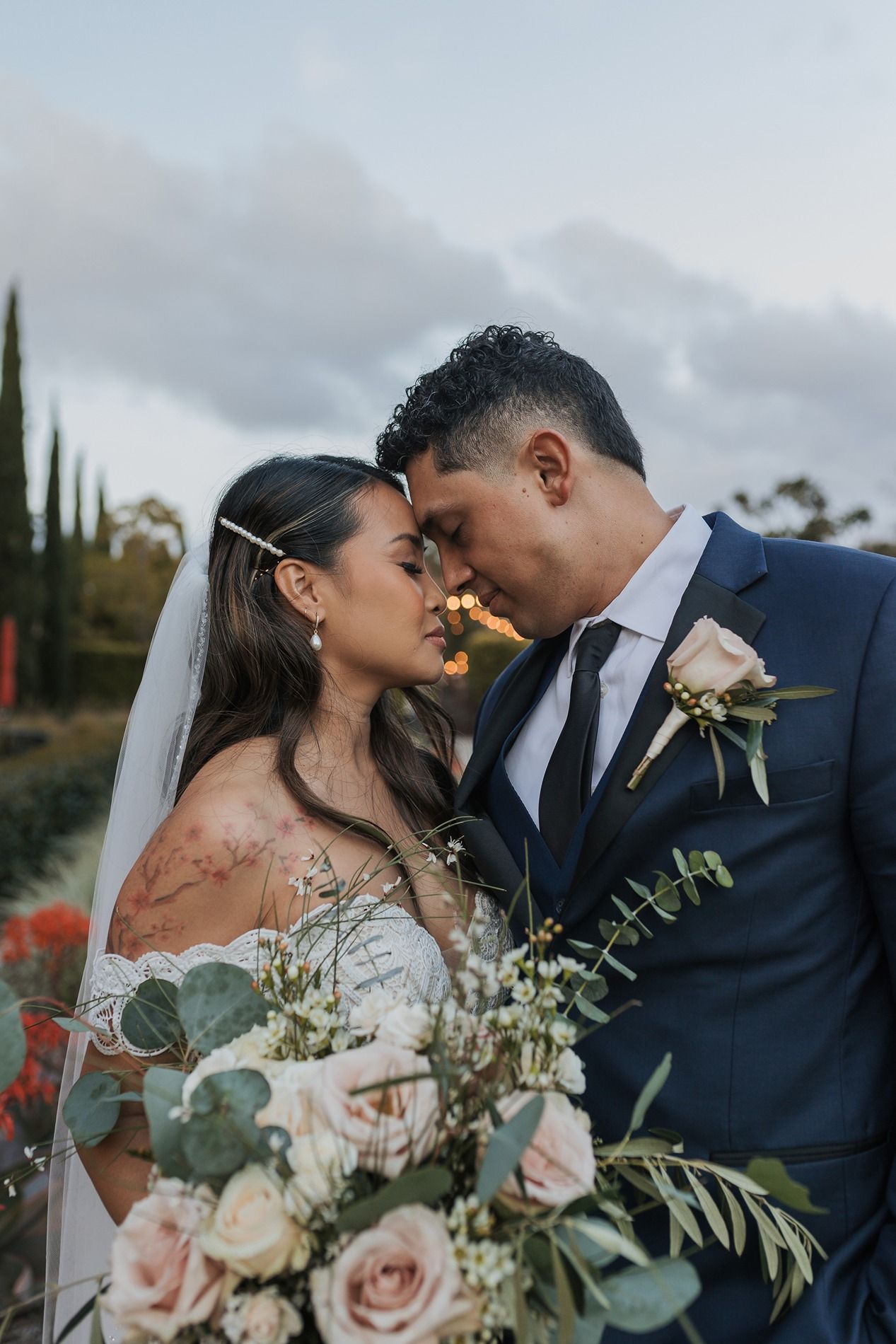 Romantic wedding couple shares intimate moments in a series of close-up portraits with flowers and greenery at Liberty Station in San Diego.