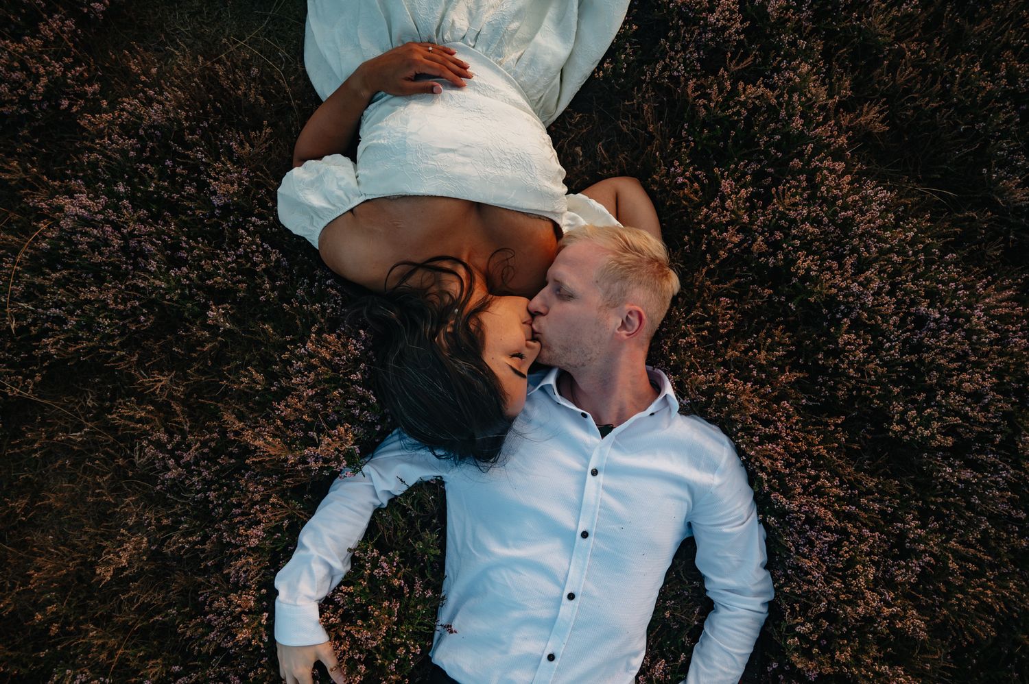 A couple in western attire and cowboy hats share romantic moments in a series of outdoor photo poses.