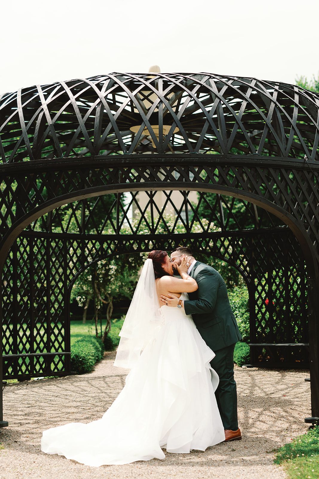 A romantic wedding couple shares a tender moment under a decorative garden arbor in a sequence of photos.