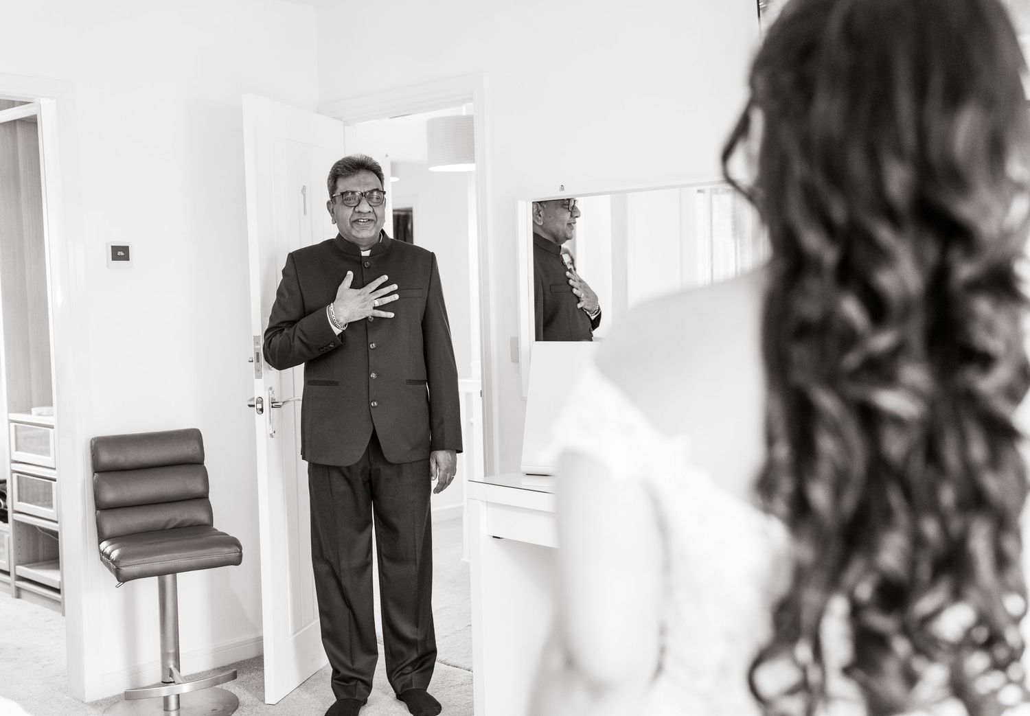 A series of black and white wedding photos showing preparations and moments before the ceremony in a bright hallway.