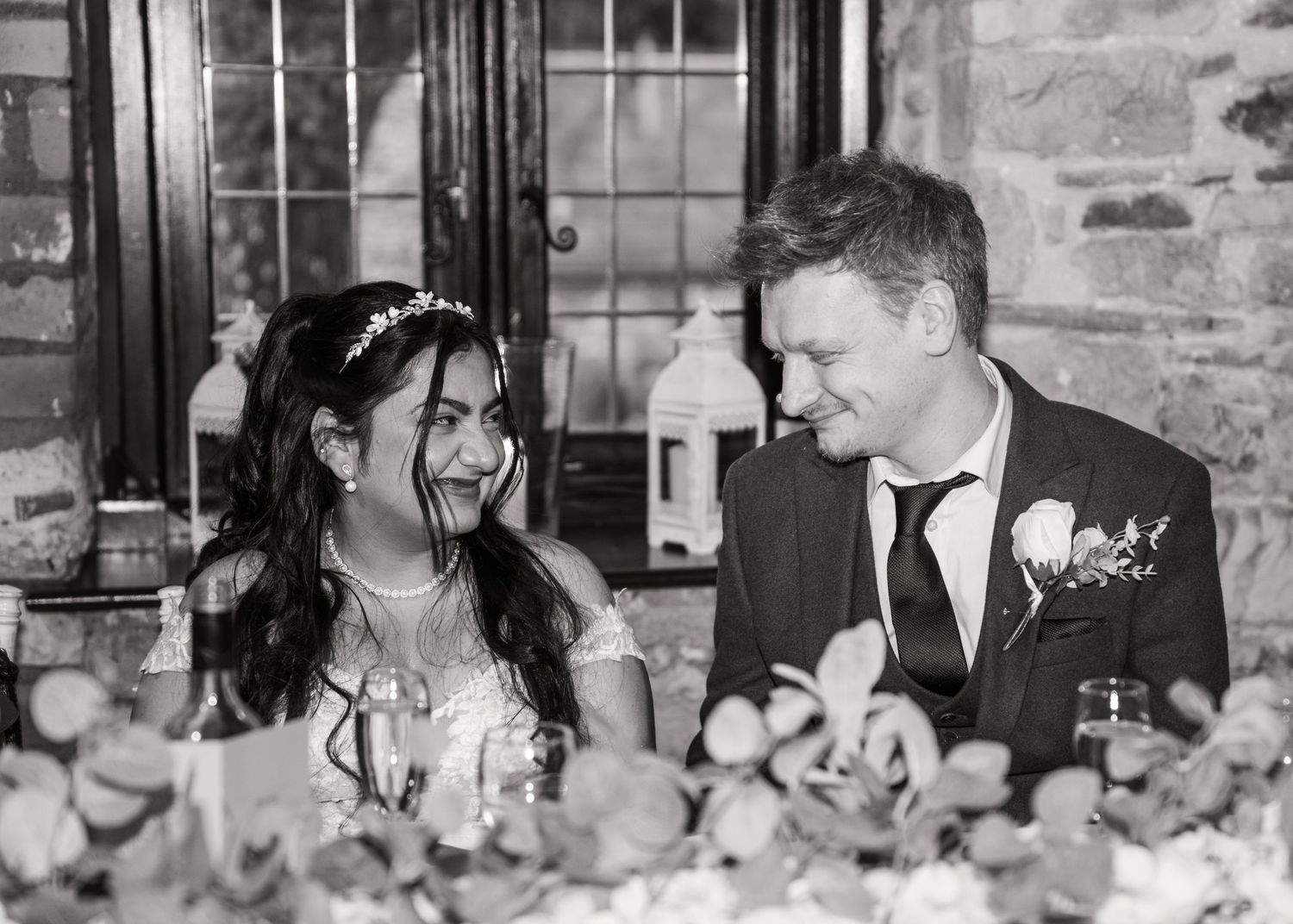 A black and white panoramic photo strip showing candid moments at what appears to be a wedding reception or party.