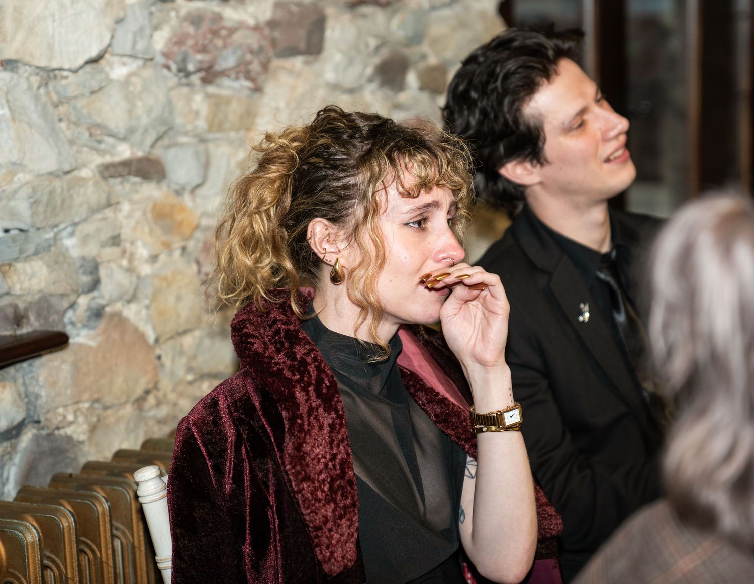 A series of candid moments captured in a stone-walled setting showing people engaged in conversation and contemplation.