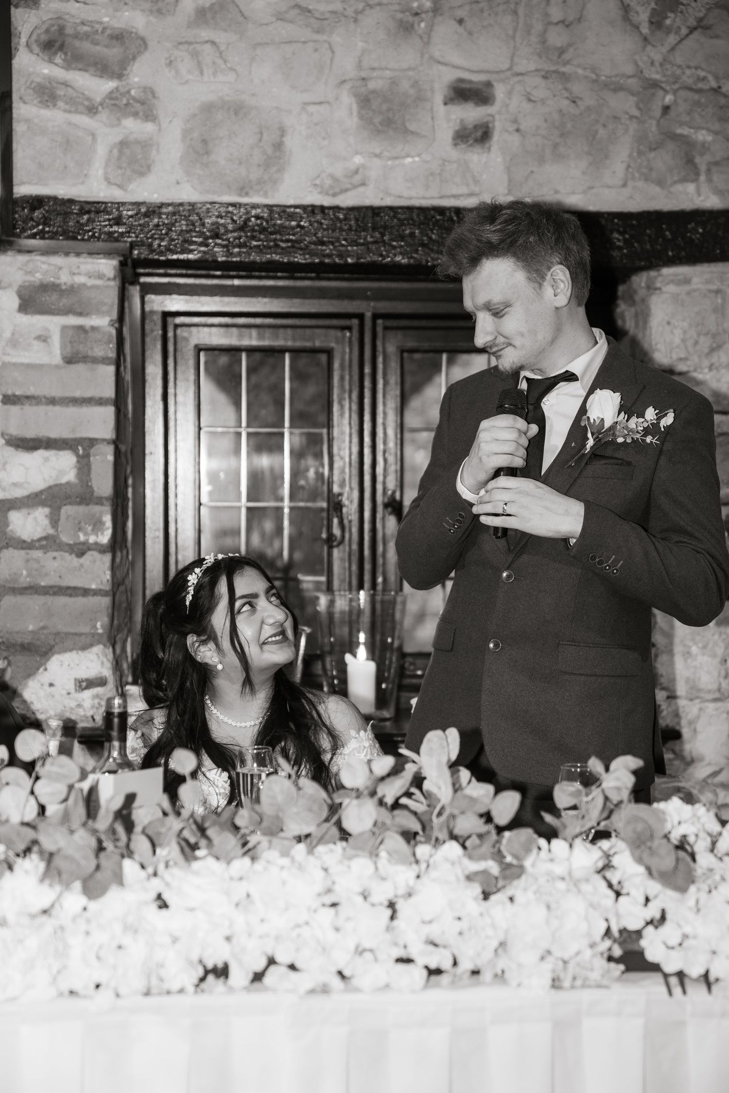 A sequence of black and white photos showing a couple laughing and interacting at a wedding reception.