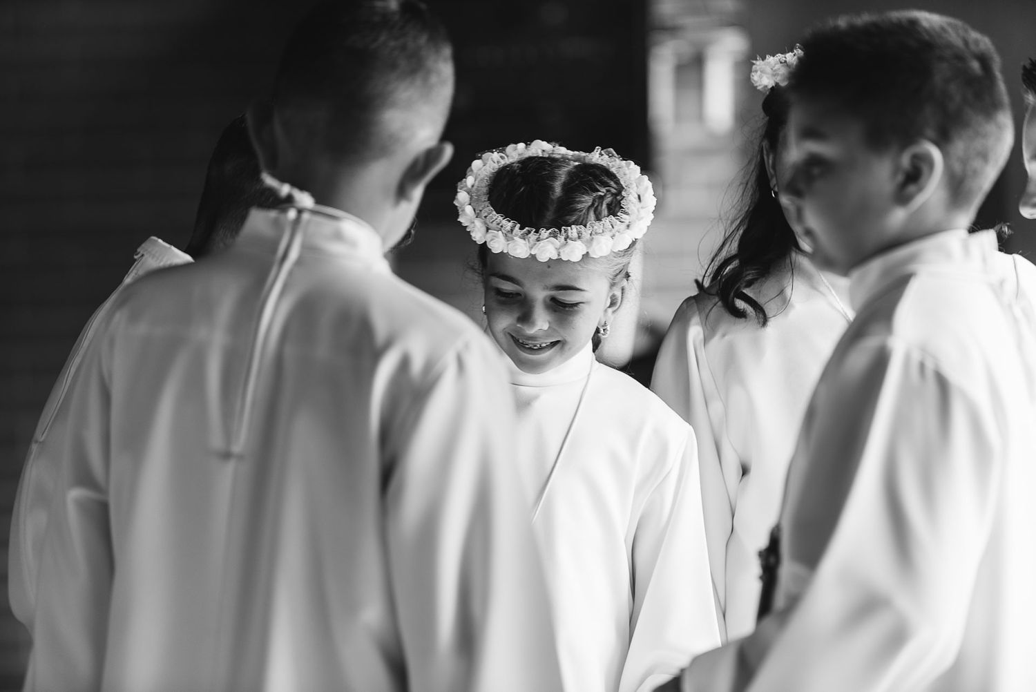 Children in white ceremonial robes gathered during religious service.