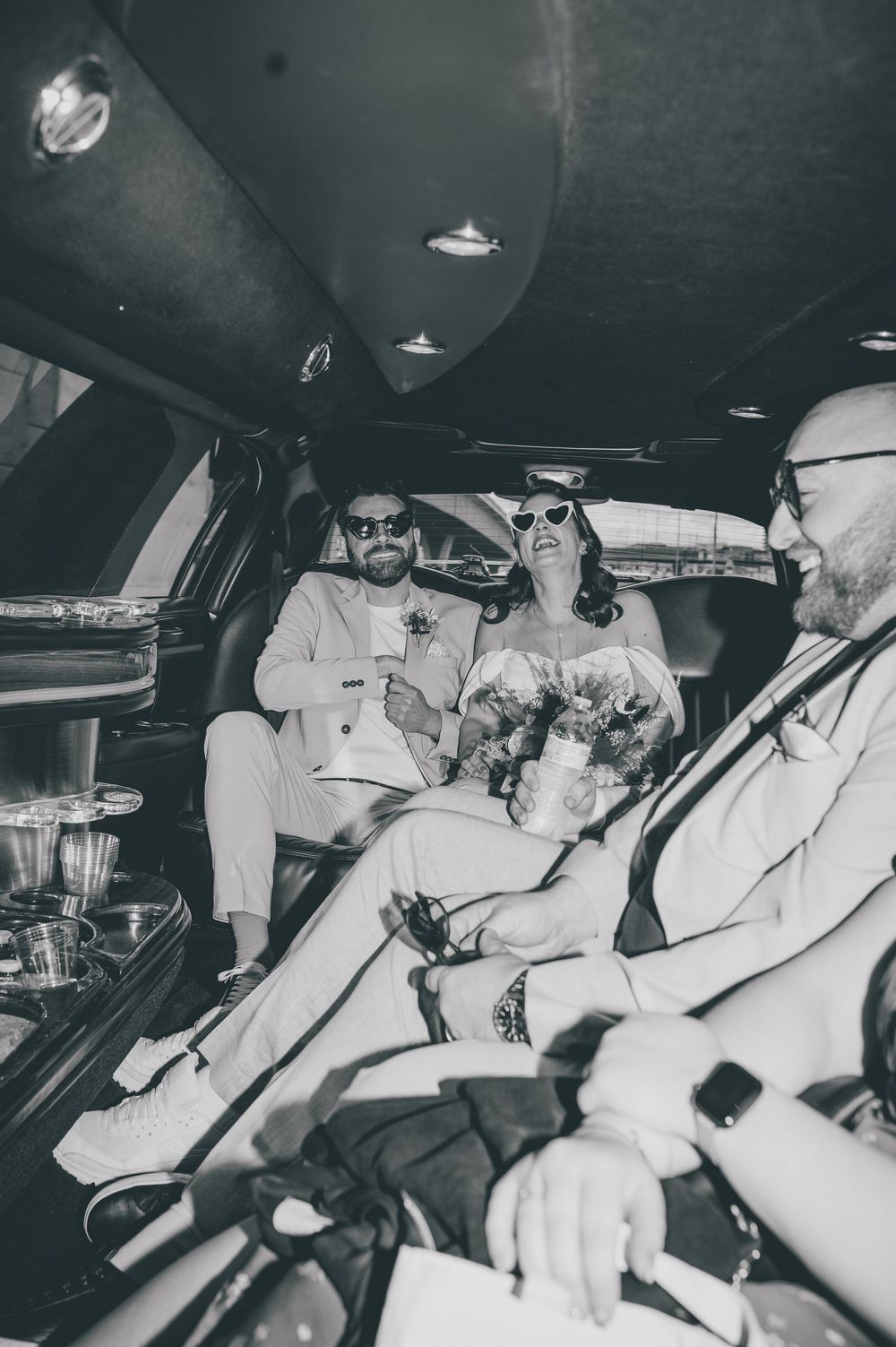 Vintage black and white photograph showing police officers in a patrol car during a nighttime operation.