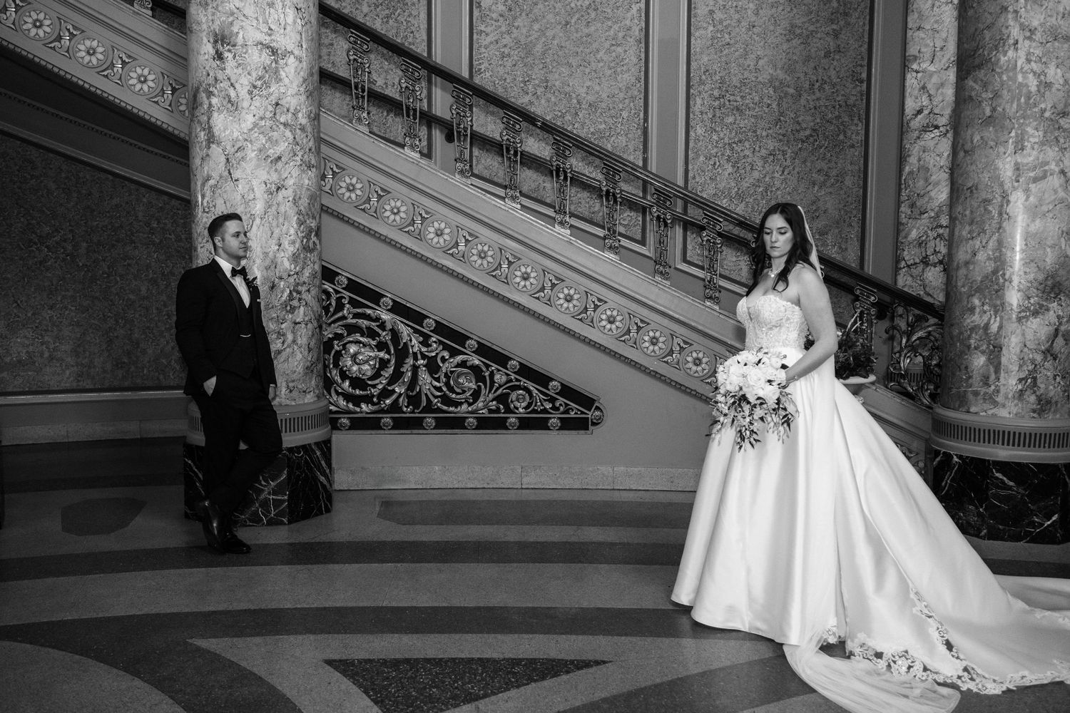 Black and white wedding photograph showing a couple posing on an elegant staircase with ornate details the Rialto Square Theatre.