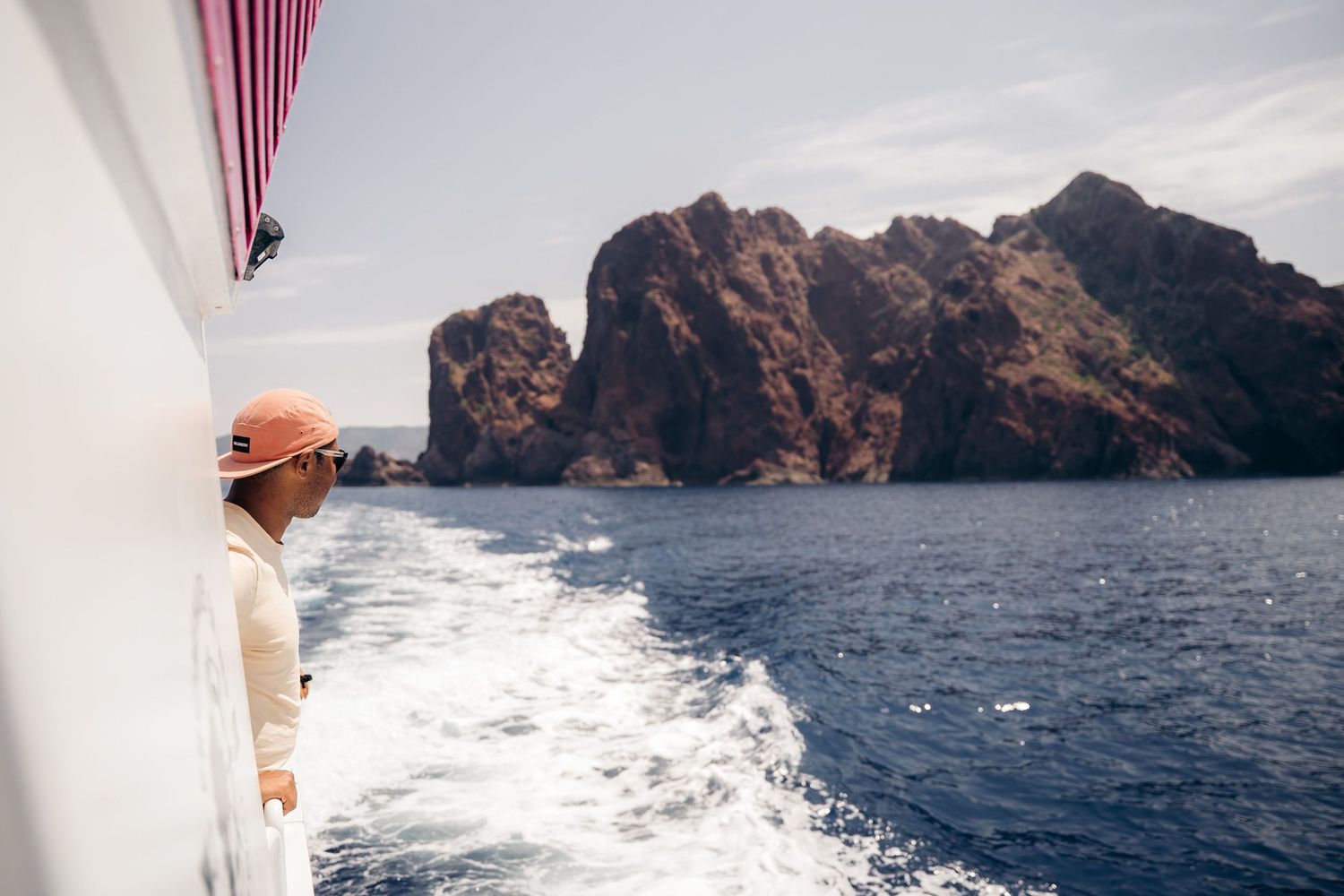 Excursion en bateau dans la réserve de Scandola en Corse avec la mer méditerrannée bleue et les roches rouges en arrière plan