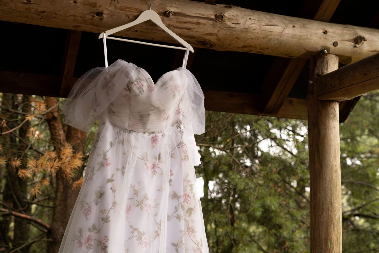 A rustic outdoor wedding ceremony setup with wooden beams and flowing white fabric draping overhead during a wedding in Lincolnshire.