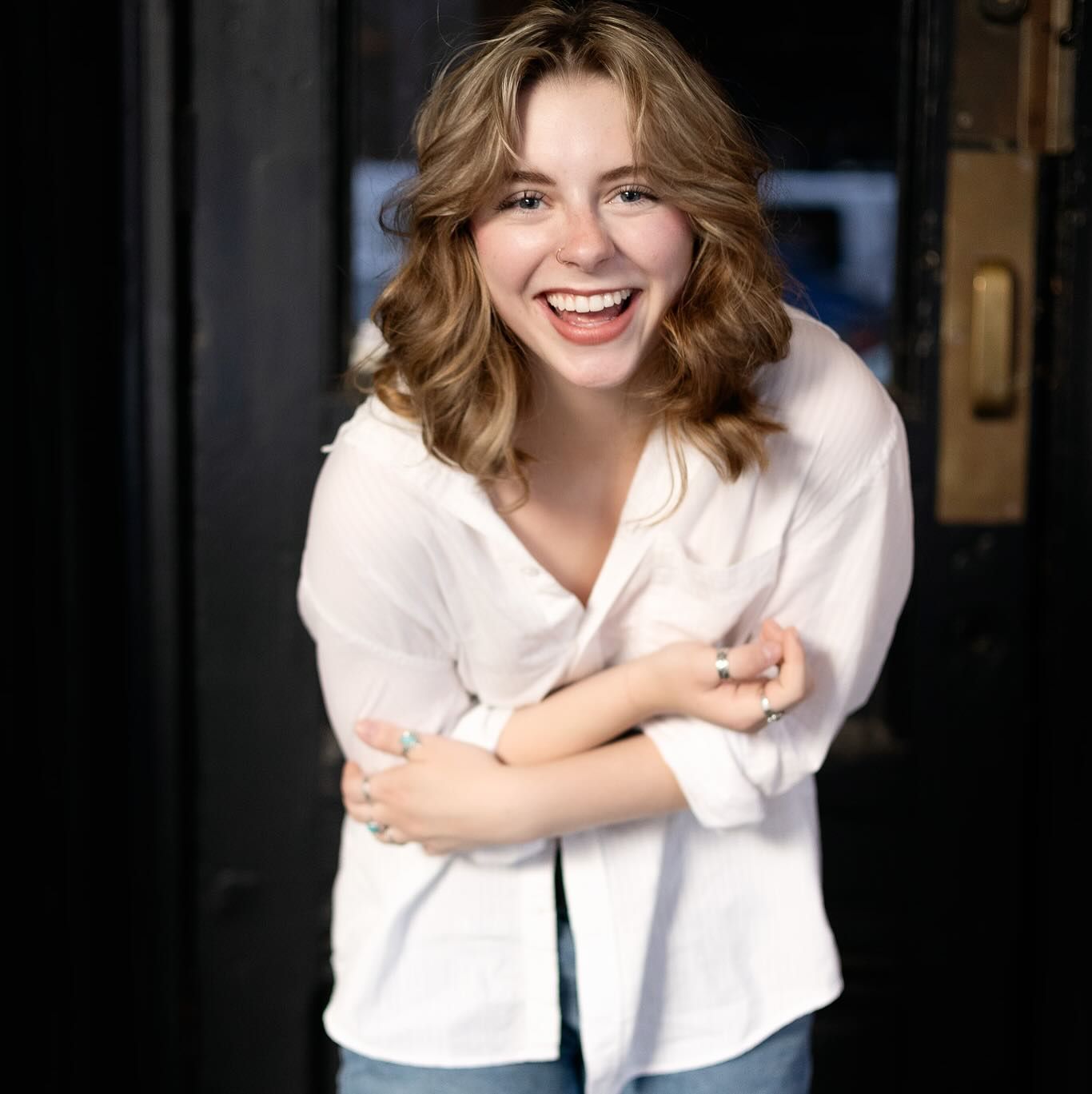 Person in white button-down shirt poses in multiple candid shots against dark background.