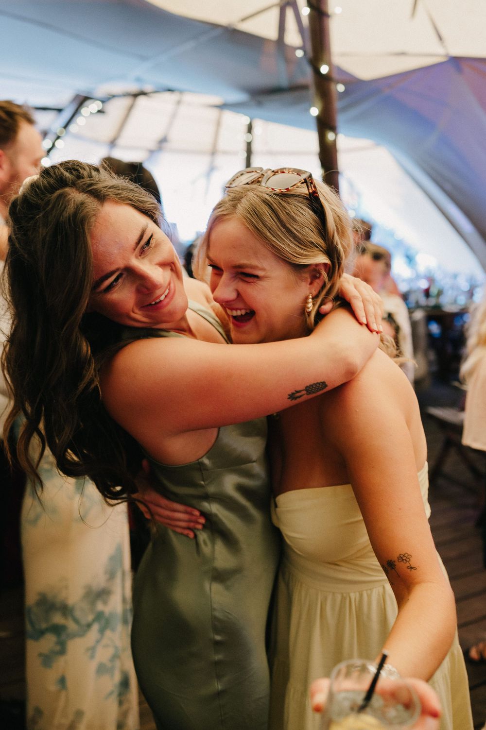Wedding guests sharing an emotional embrace on the dance floor during a reception celebration.