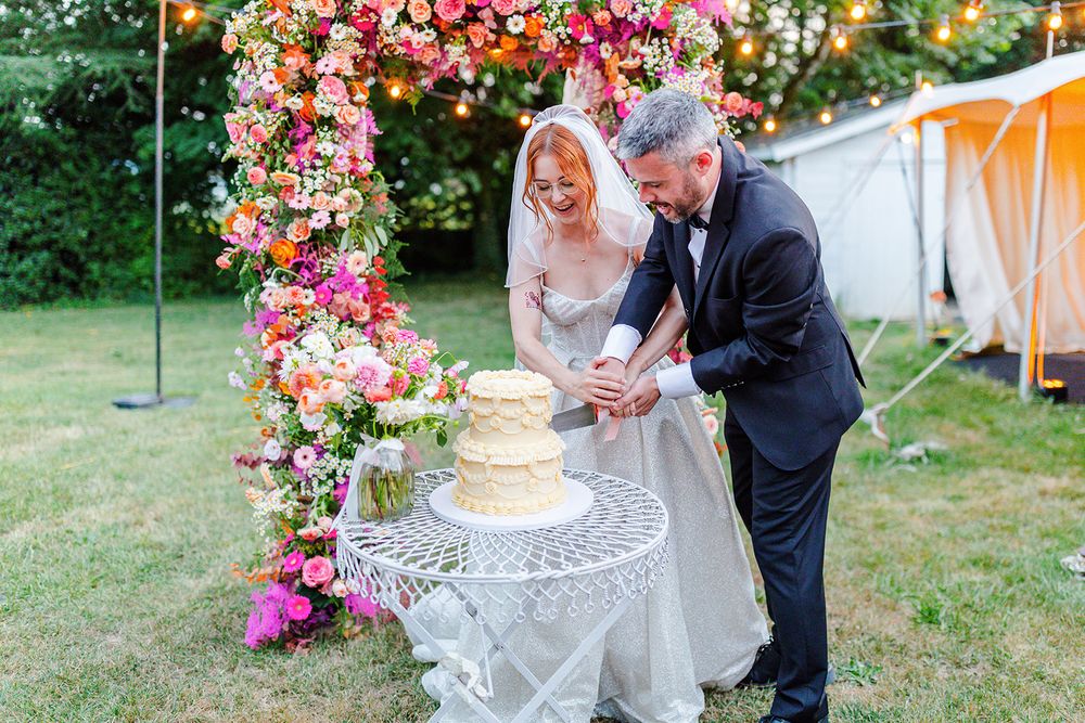 Couple sharing a sweet moment together during their outdoor garden wedding ceremony surrounded by colorful floral arrangements.