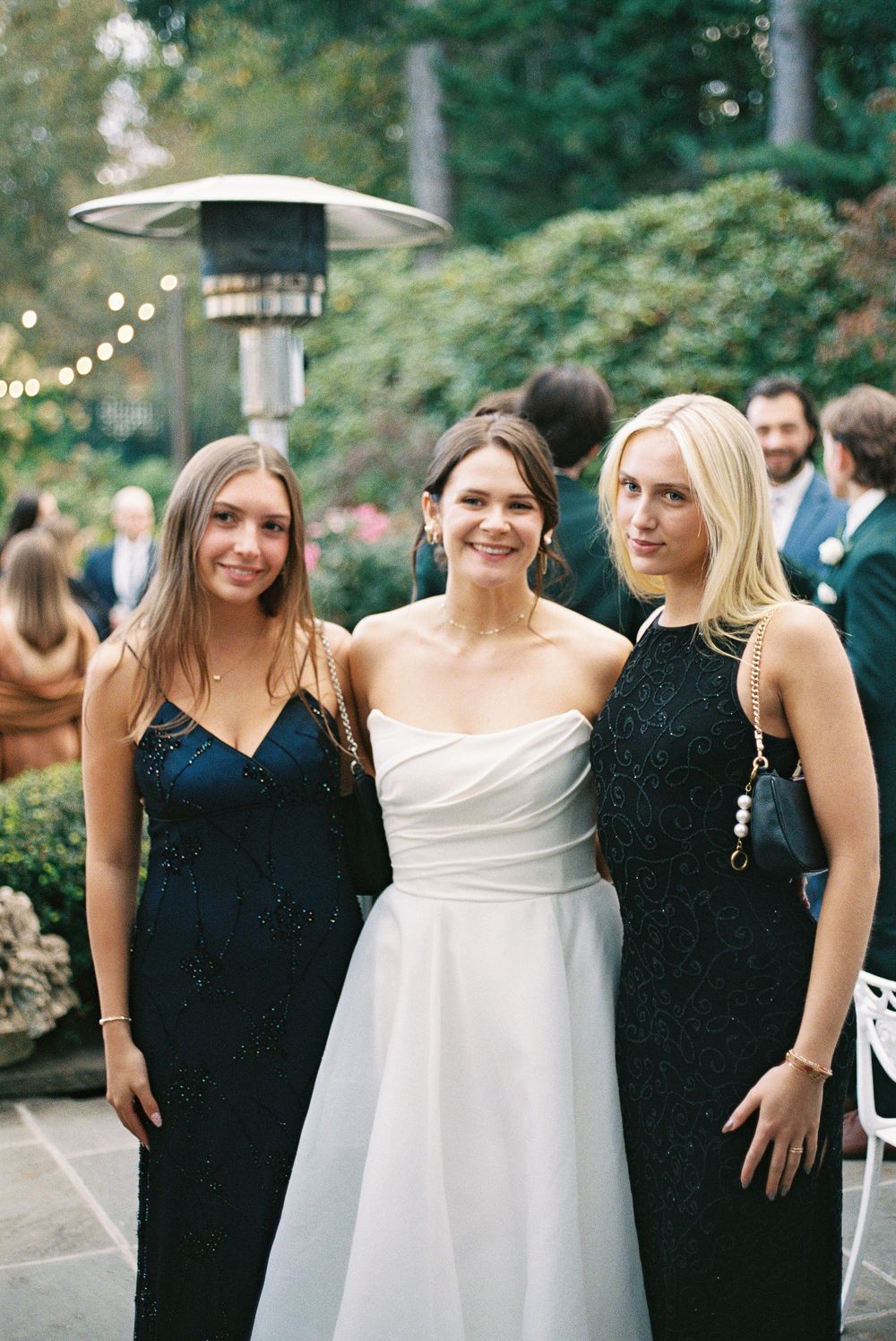 Wedding party wearing black and white formal attire posing together outdoors.