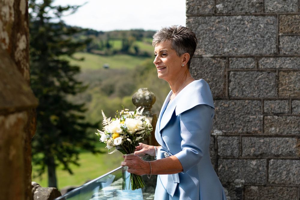 Bride looking at view from balcony at Devon Wedding venue Bovey Castle