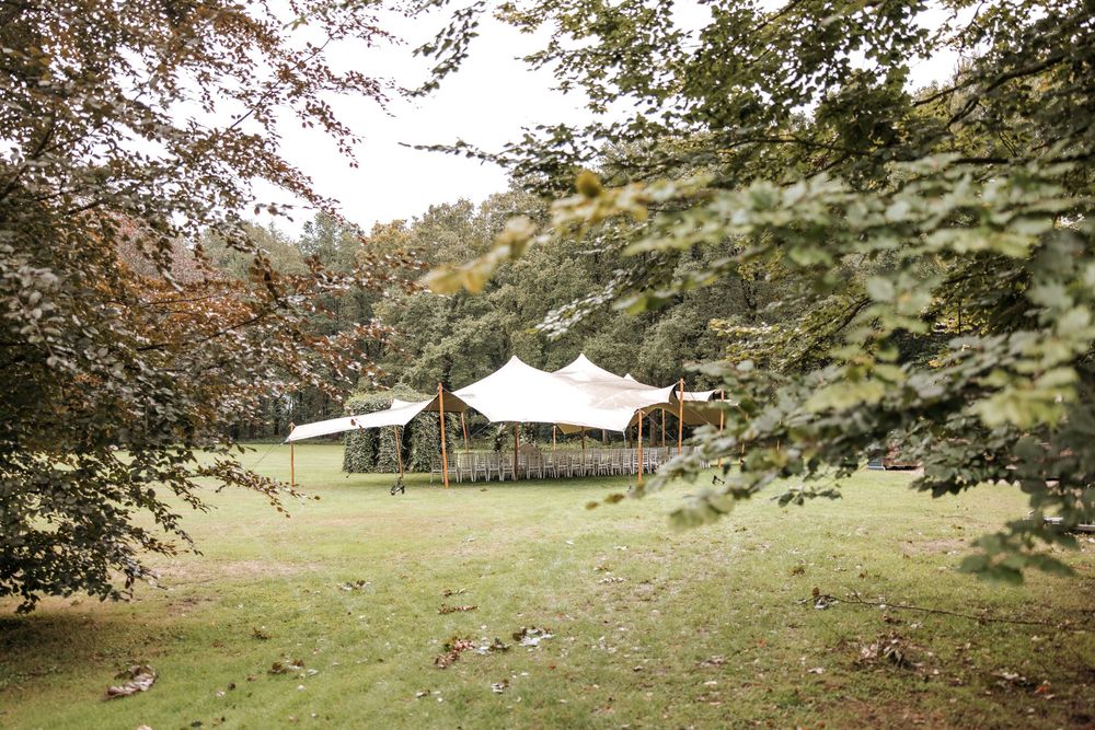 Elegant white stretch tent set inthe lush green lawn of Landgoed van Voorst before the wedding ceremony