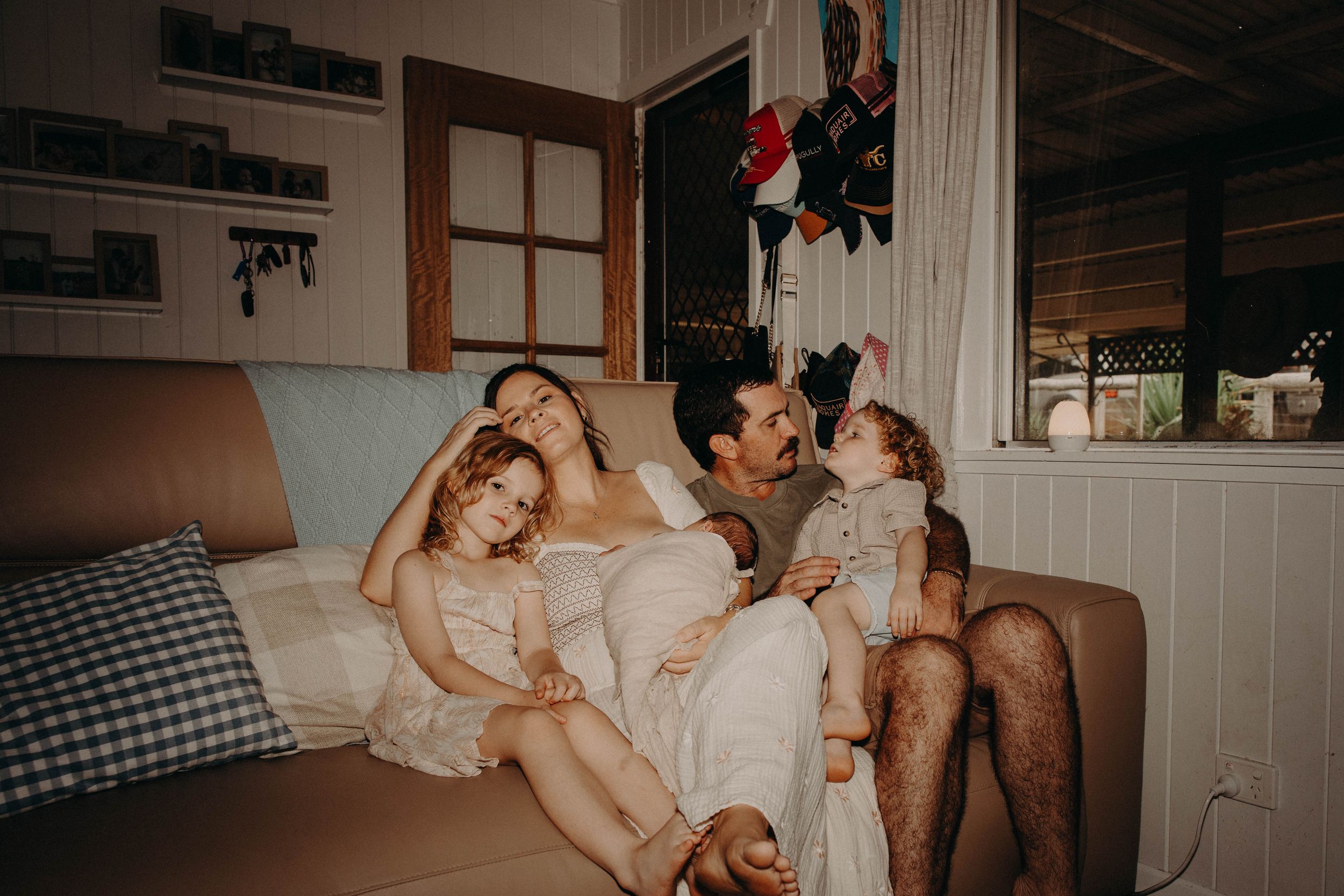Relaxed family lounges together on couch in cozy living room at home.