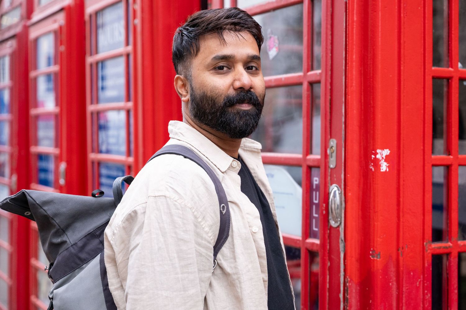 A man photographs in a professional studio with white backdrop and softbox lighting equipment.