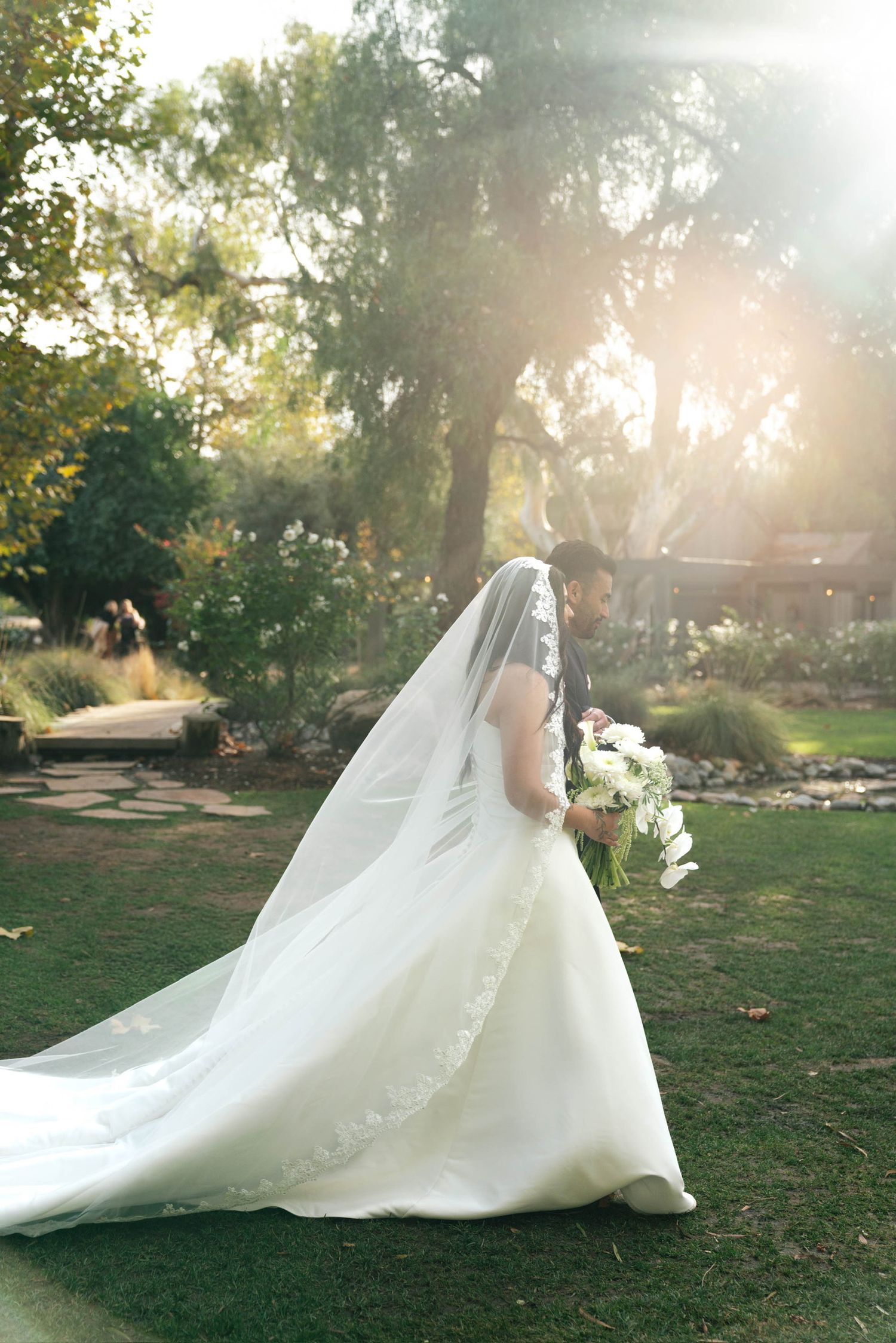 Dad walking bride down the aisle as the sun shines through her veil in Temecula, CA