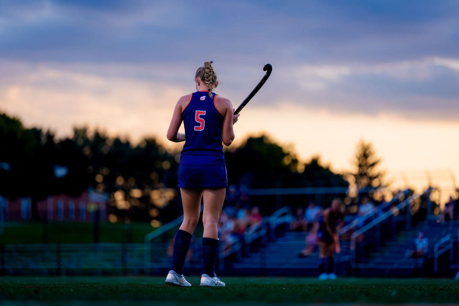 Hershey Trojans field hockey player, #5, silhouetted at sunset vs Mifflin County, by Deanna Fox, SportsFox Photography based in Hershey PA