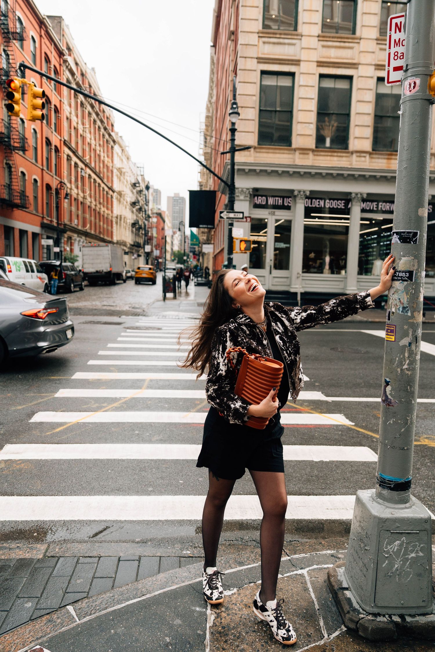 A joyful moment captured on a busy street corner in New York City with classic brick buildings and crosswalks in view.